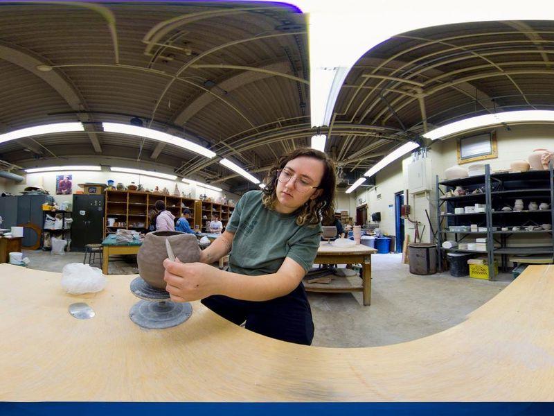 Panoramic view of student sculpting in an art studio